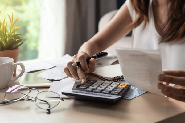 Woman using calculator with receipt